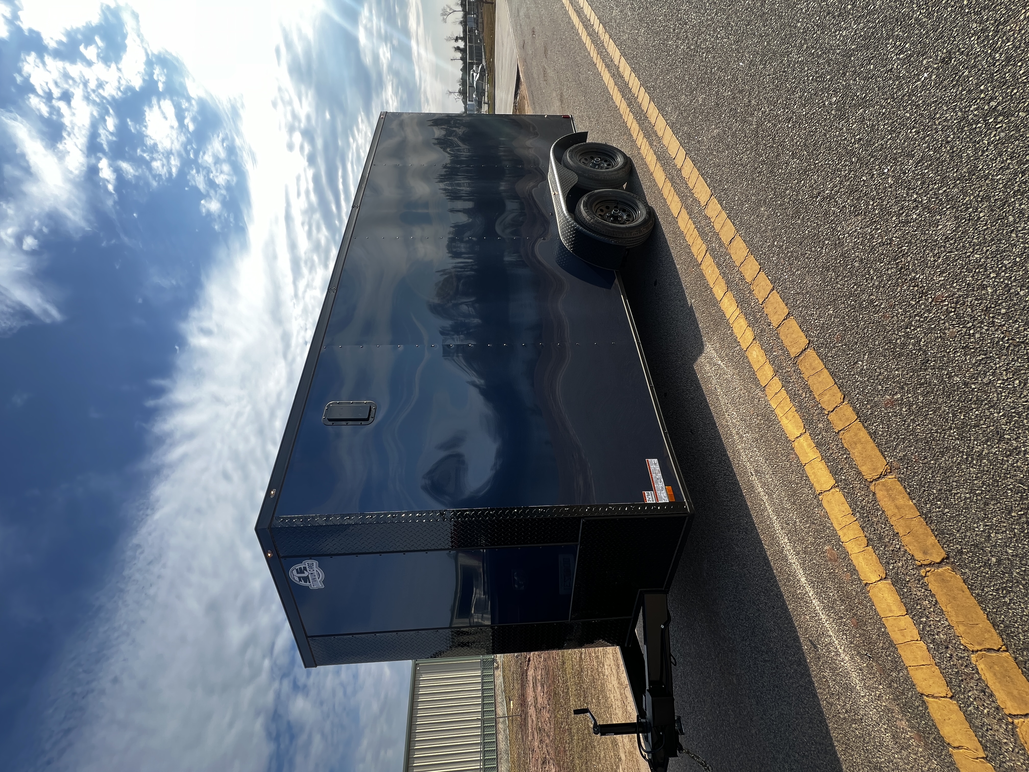 Indigo blue enclosed 7x16 tandem axle trailer — blackout trim with aluminum sidewall vents and Polycore exterior panels