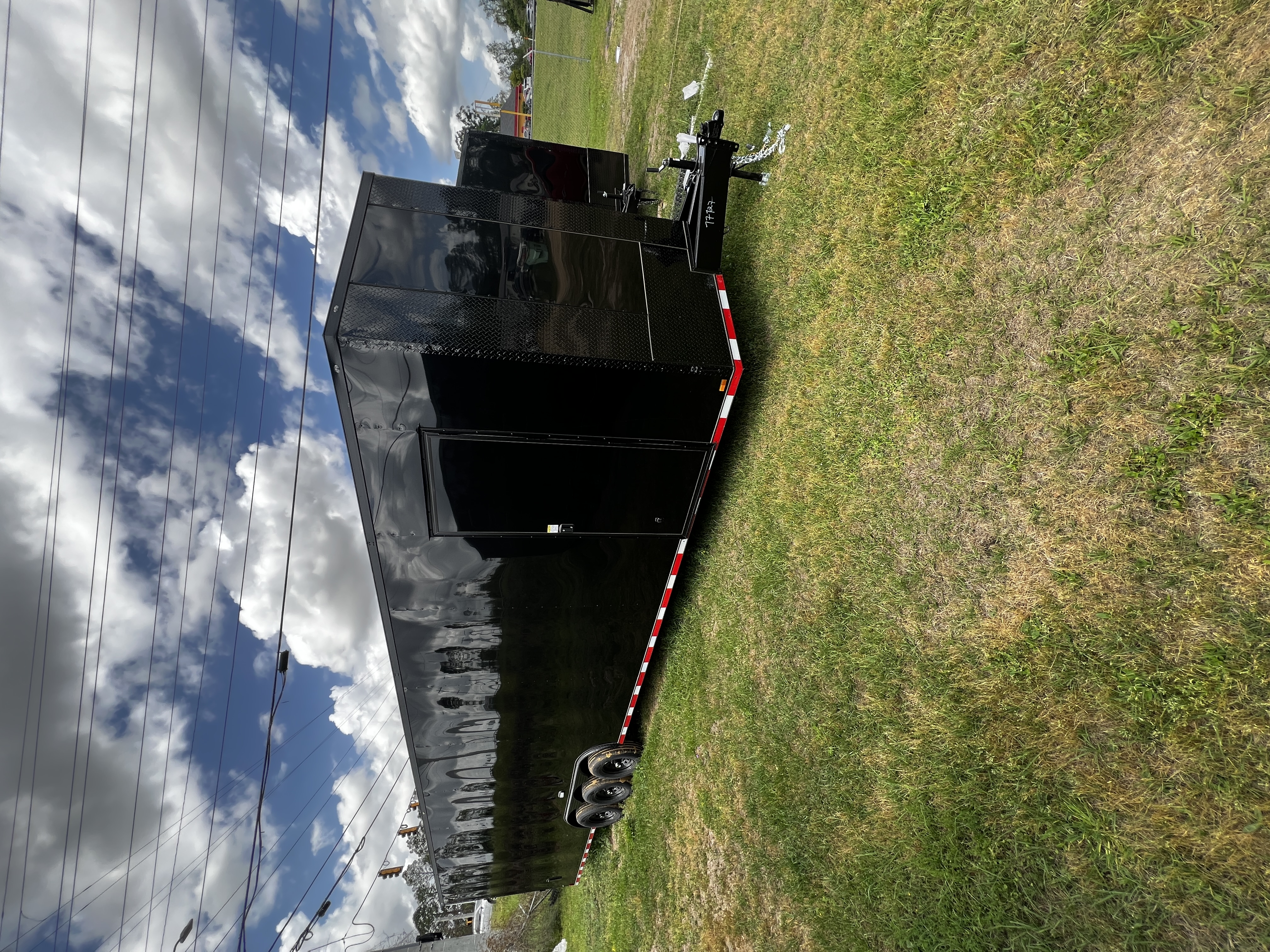 Black enclosed 8.5x36 triple-axle two-car hauler trailer with blackout trim, triple-tube tongue, and 7000lb axles