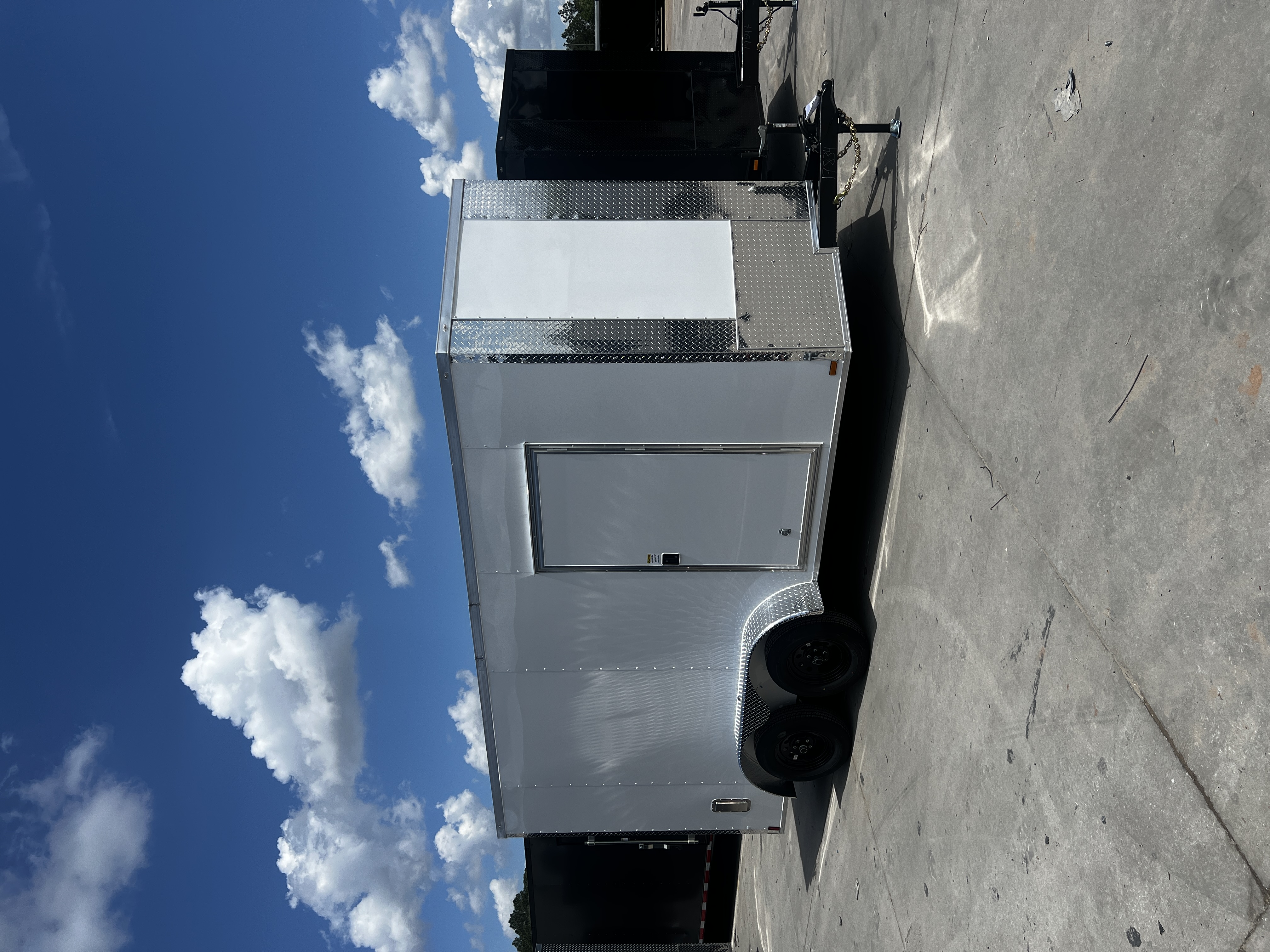 White enclosed 7x14 tandem axle cargo trailer — passenger-side view showing RV entry door and chrome trim package