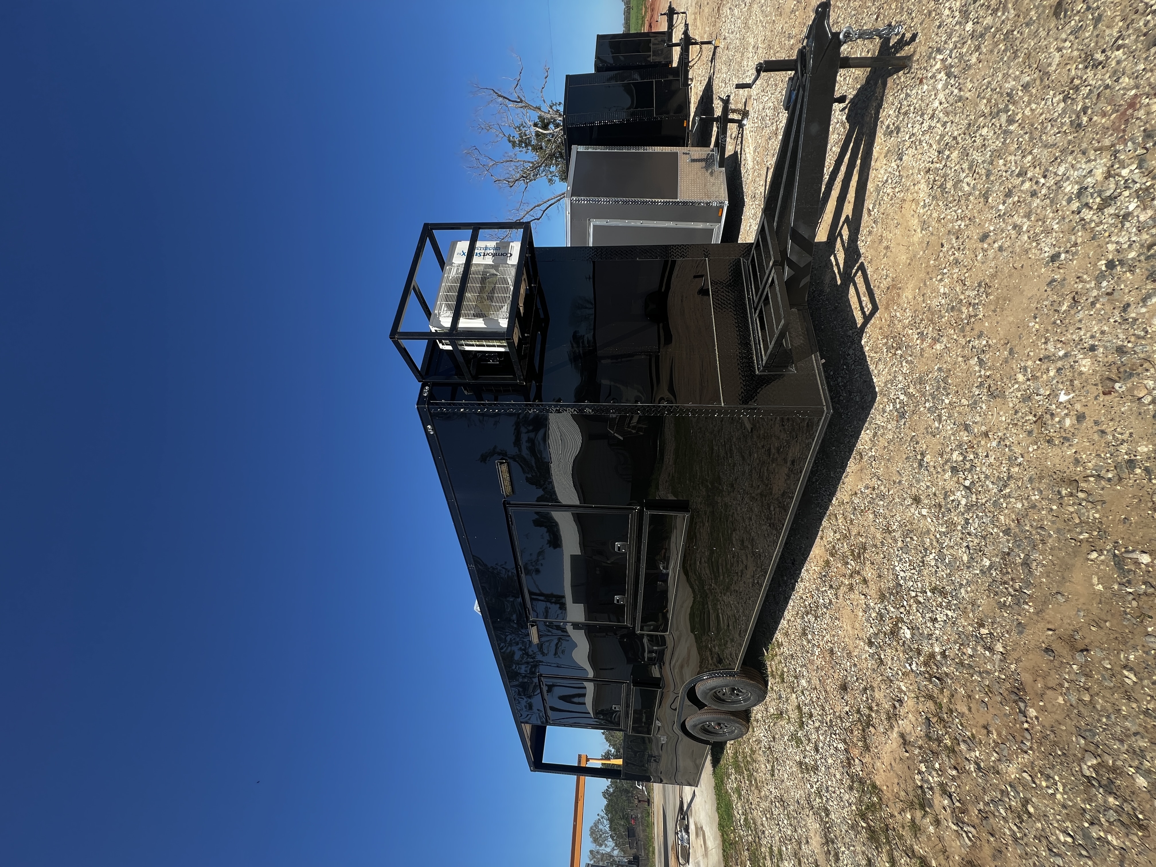 Black enclosed 8.5x24 BBQ porch concession trailer — 130-inch triple-tube tongue, propane cage mounts, and mini-split AC for climate control