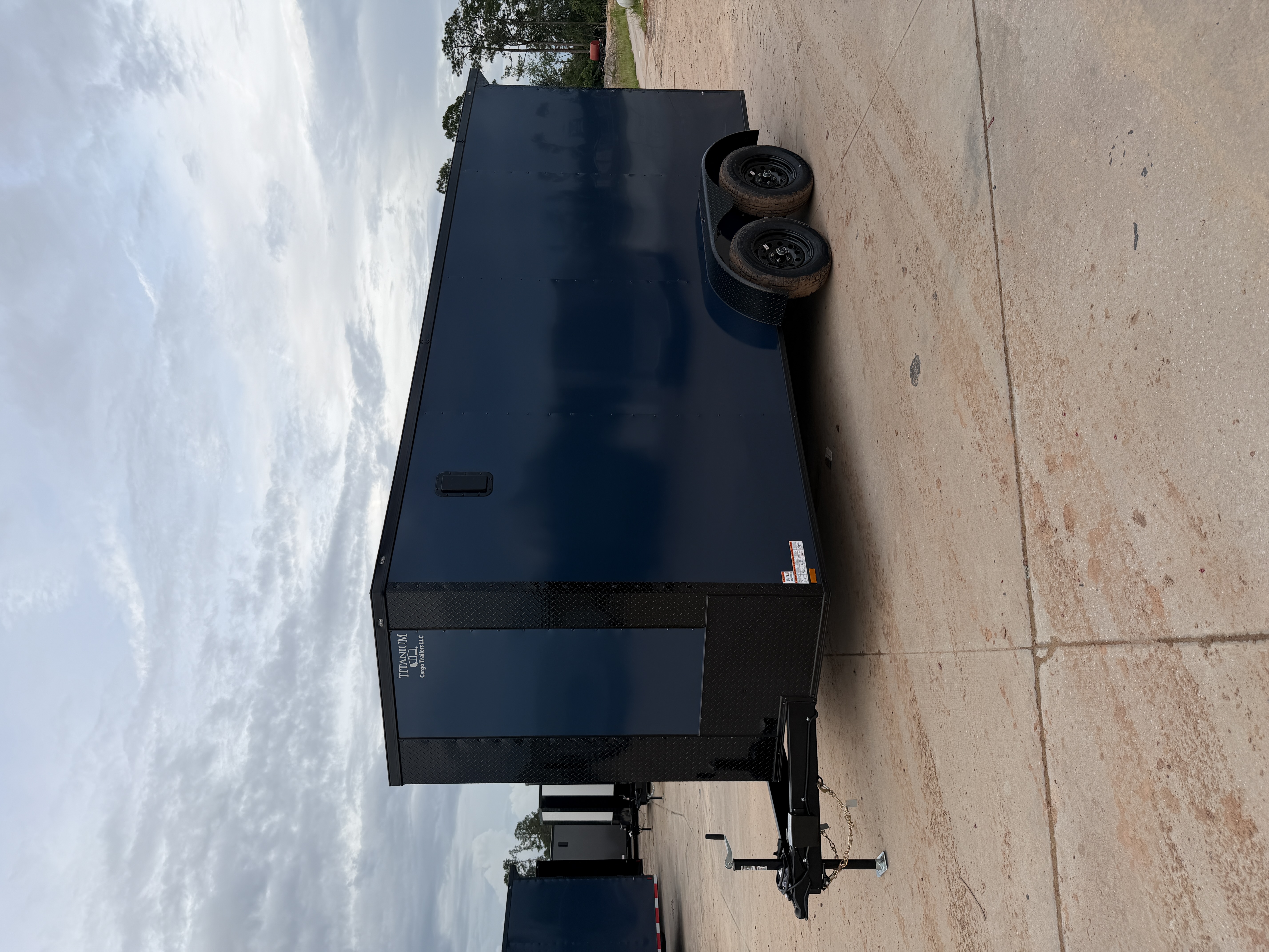 Indigo blue enclosed 7x16 tandem axle trailer with upgraded blackout package — exterior side view