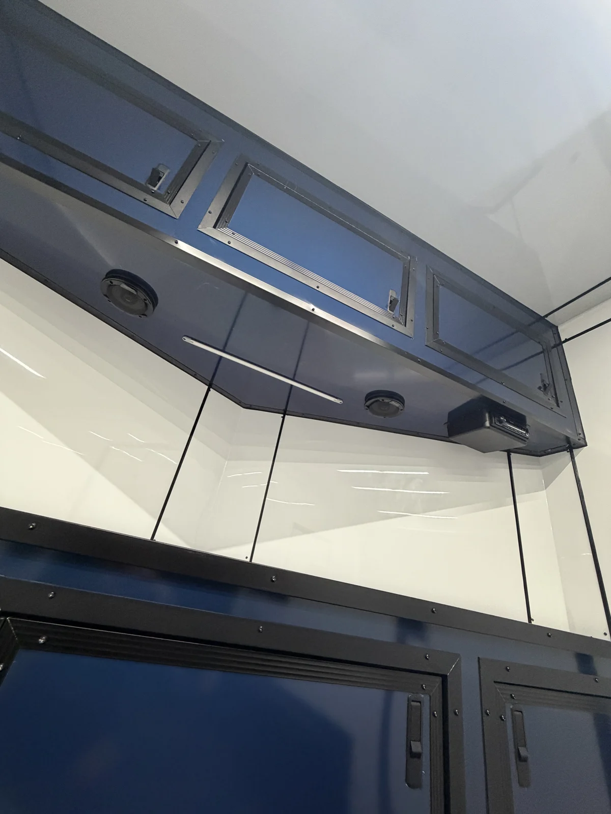 Indigo Blue base and overhead cabinets with speakers, radio, and a light strip in the motorcycle trailer