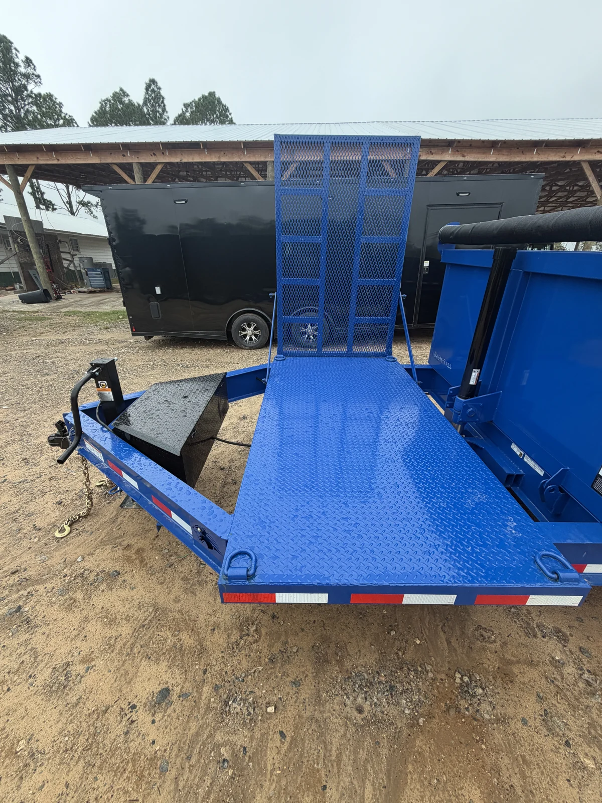 Royal Blue tread plate front deck with tie-down rings, upright mesh foldout ramp, and black tongue toolbox