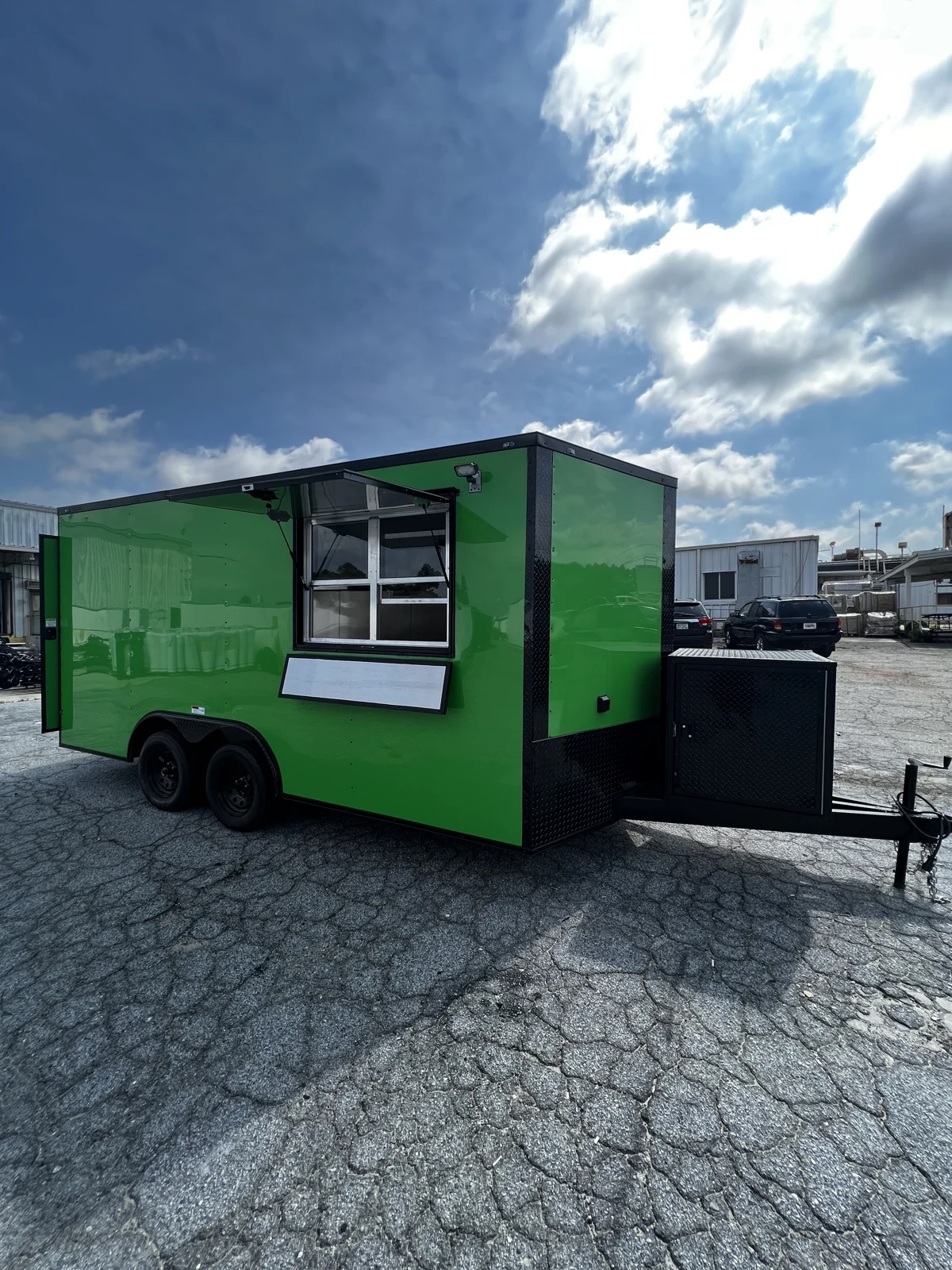Electric Green Blackout concession trailer with its service window open, exterior window lights, and serving shelf