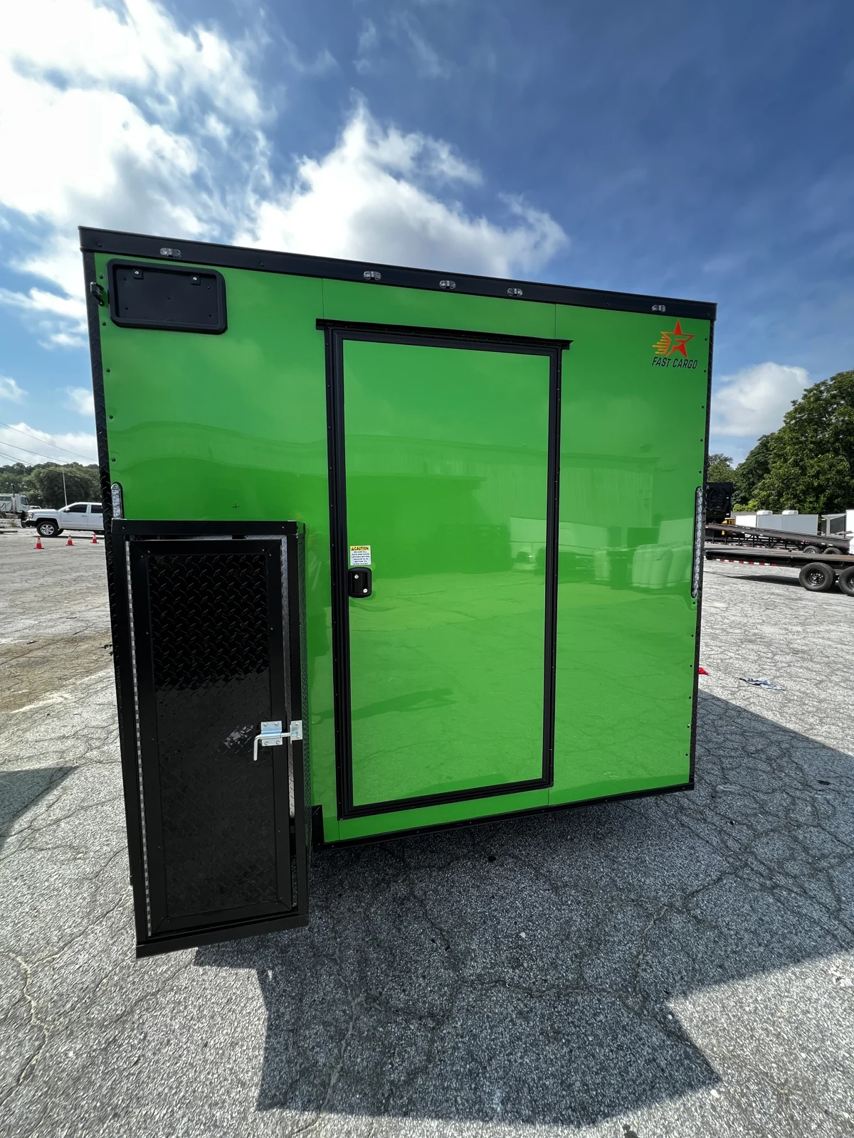 Rear of the Electric Green concession trailer with a black-trimmed entry door and open exterior compartment